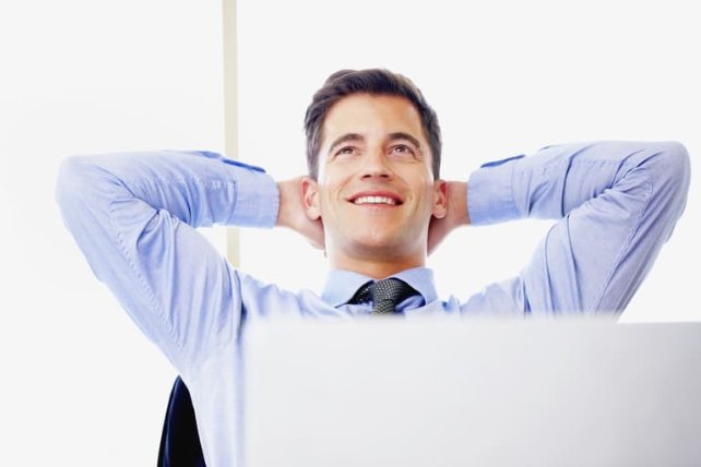 happy man with his laptop smiling with his hands behind his head