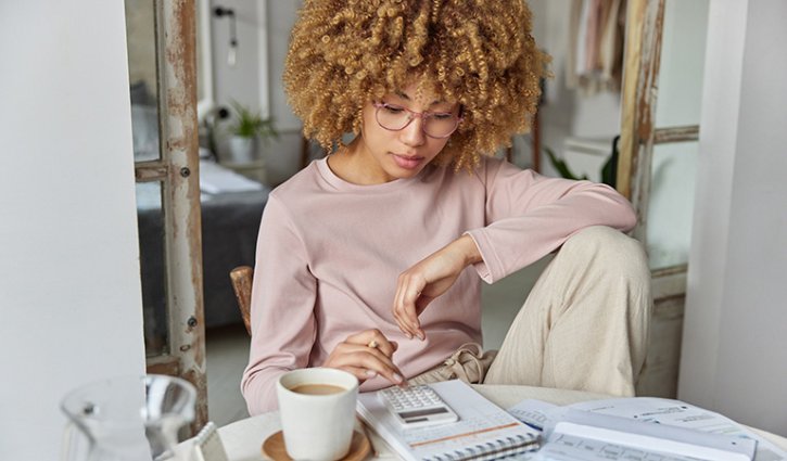 woman calculation for work with a calculator and a coffee