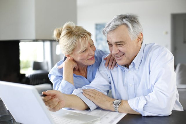 older men and woman behind a laptop